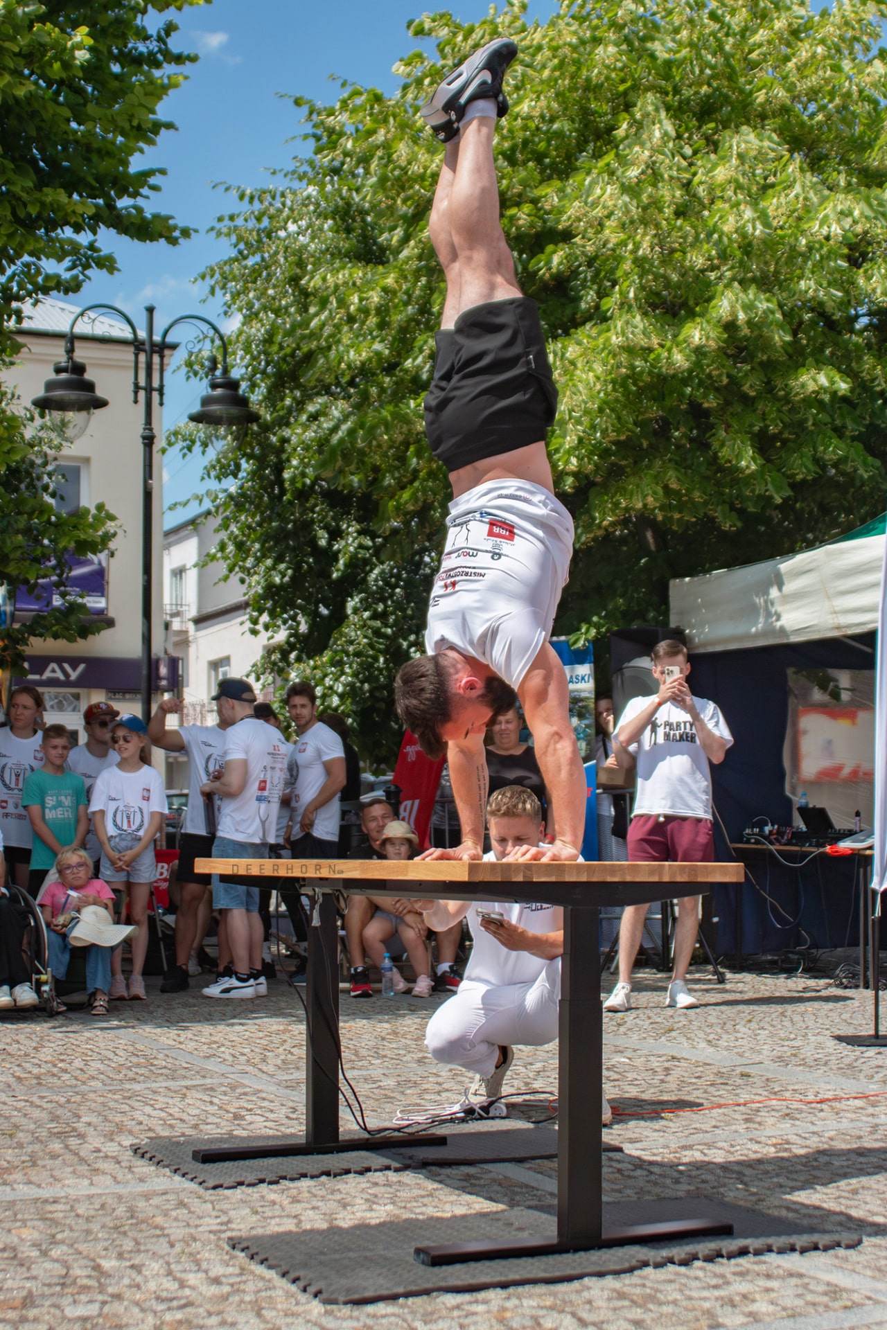 a performer doing a handstand on an adjustable desk