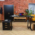 Black desk with other wood and metal furniture