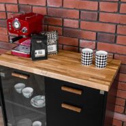 black cabinet under the coffee machine with cups and coffee