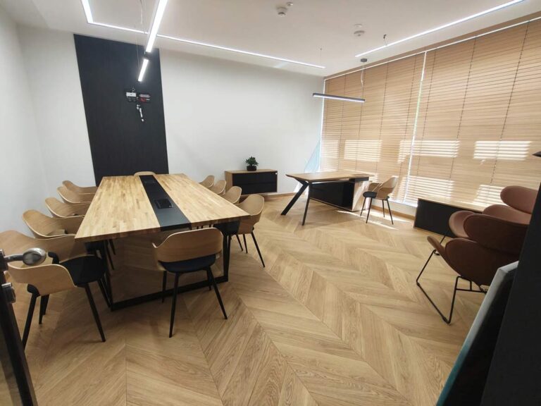 Modern office with a large conference table and a desk by the window