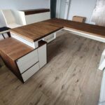 Corner desk in dark wood shade with white accents in a modern interior