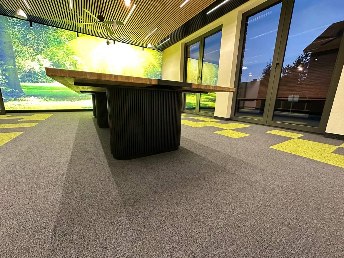 Stół konferencyjny na wymiar w eleganckiej sali z zielono-szarą wykładziną