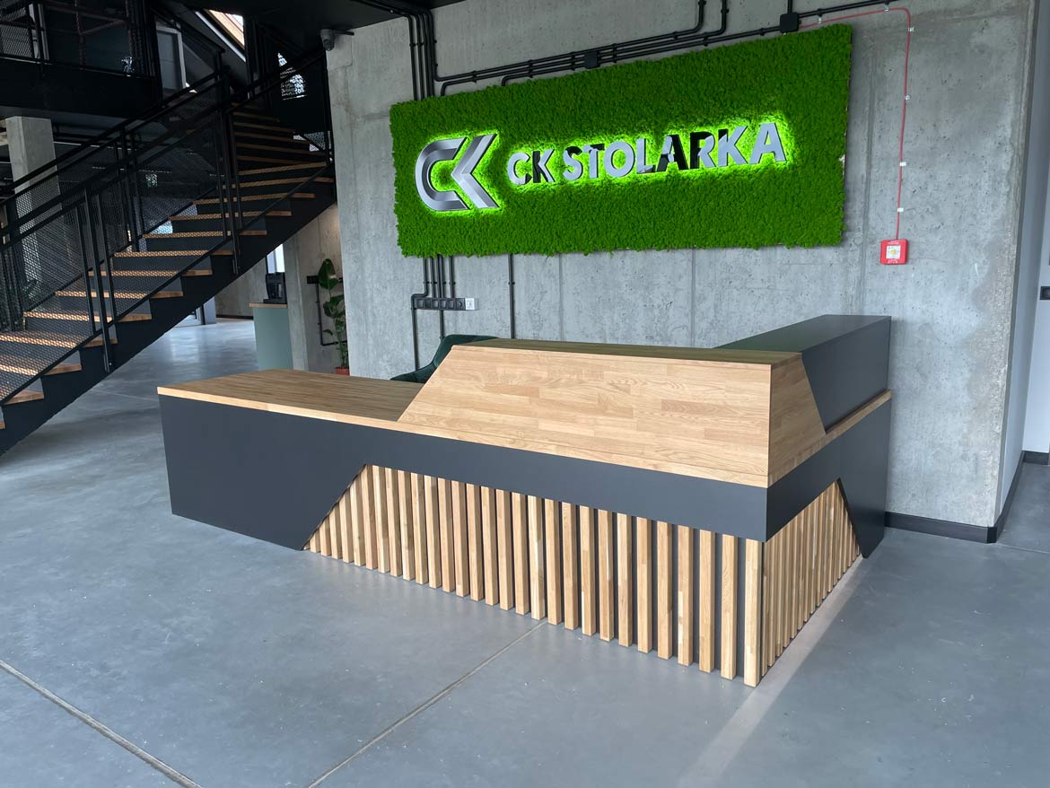 Modern reception counter with wooden top and geometric front in industrial interior