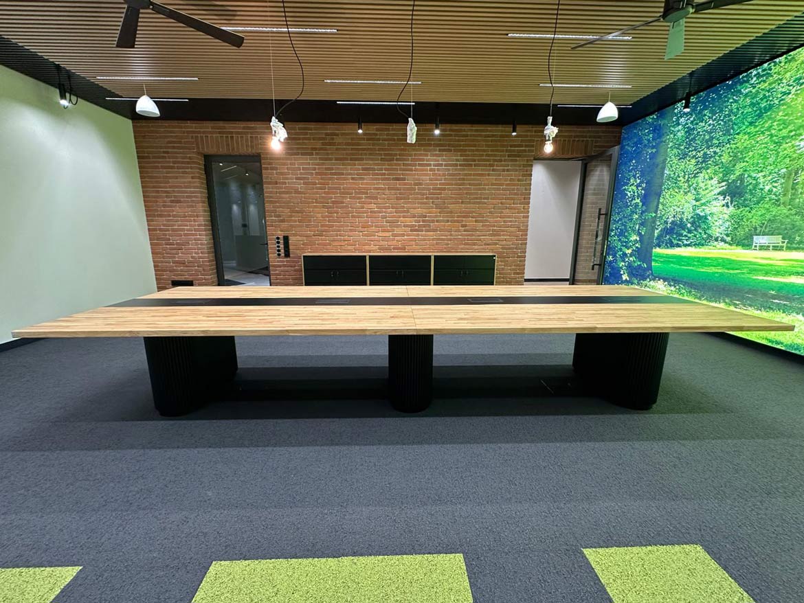 Nowoczesny stół konferencyjny z litego drewna w przestrzeni biurowej z ceglaną ścianą