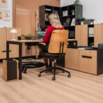 large computer desk with black base and wood-like top