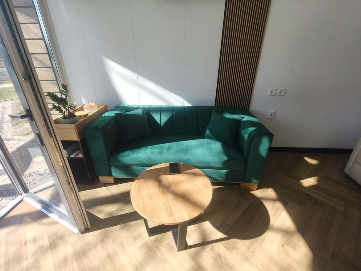 strefa wypoczynku z sofa w kolorze butelkowej zieleni dla firmy port rolniczy w swidnicy