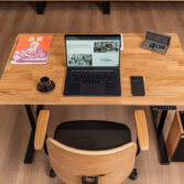 A modern solid-wood office desk designed for standing while working on a laptop