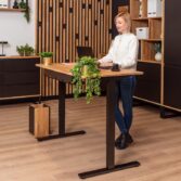 a computer desk with a natural oak tabletop and an ergonomic chair