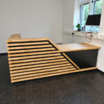 Corner reception desk with slats for the Heilkunde und Physiotherapie physical therapy practice in Ergolding, Germany