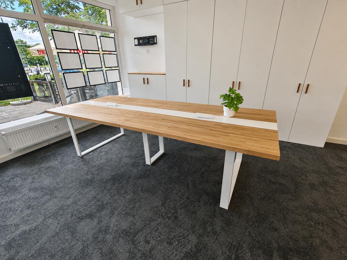 A large conference room table with white legs
