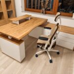 Height-adjustable corner desk for an office
