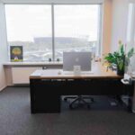 A modern office with oak furniture and a view of the National Stadium