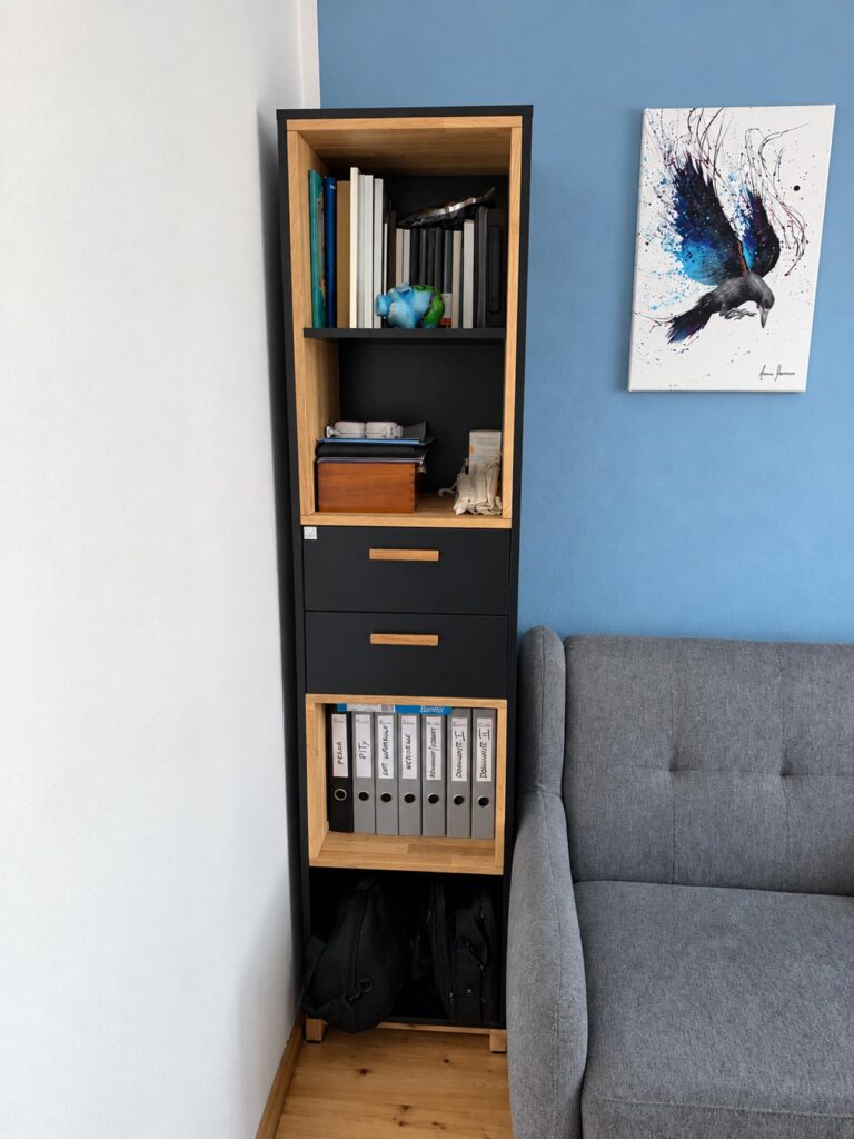 A narrow office bookcase with drawers