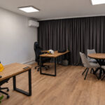 Corner desks with wooden tops and black frames in a modern office