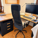 Wooden corner desk with a black frame and a storage unit for a real estate office