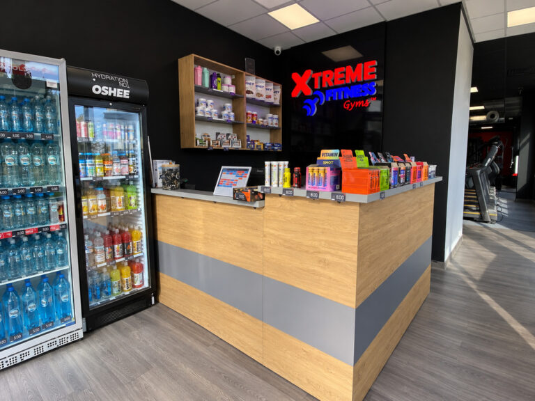 A reception desk made of furniture board with gray accents for the Xtreme Fitness club