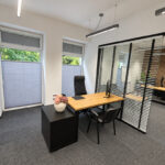 A modern office desk with a wooden top and a black storage unit