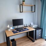 A modern workstation with an oak desk, a cabinet, and a wall shelf for a home office