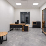 A modern office with oak furniture, black accents, and a coffee table