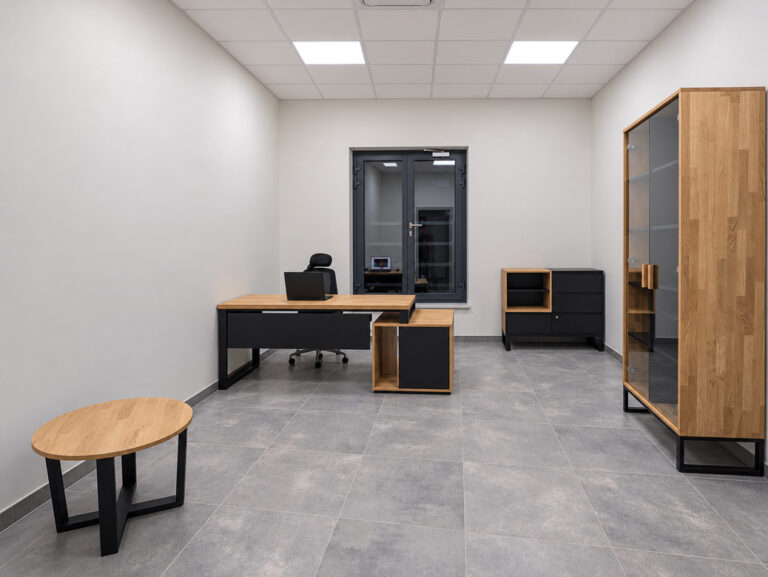 A modern office with oak furniture, black accents, and a coffee table